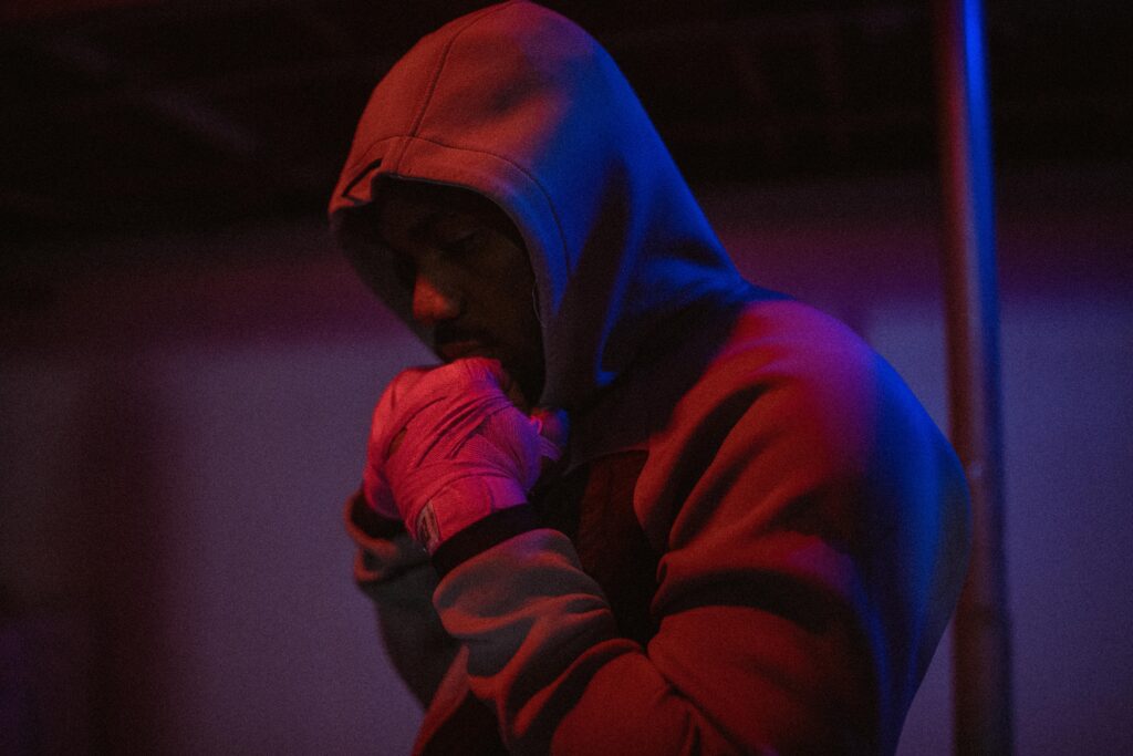 A focused African American man in a hoodie prepares for training in an Ottawa boxing gym.
